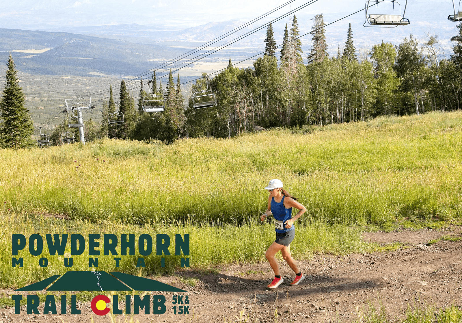A woman runs uphill on a dirt trail surrounded by grassy fields and trees, with ski lift chairs above. Text reads "Powderhorn Mountain Trail Climb 5K & 15K." Mountains are visible in the distant background.