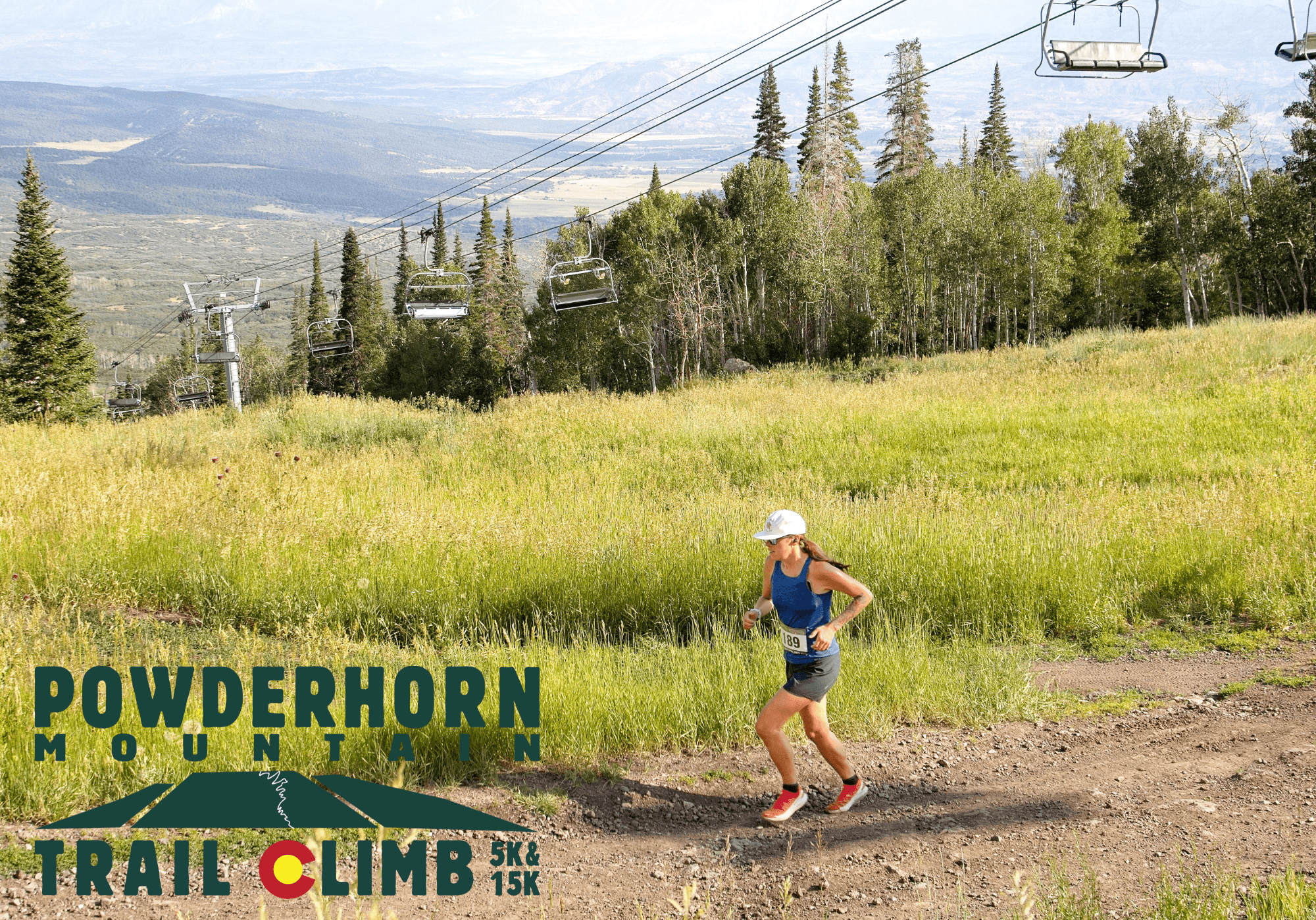 A woman runs uphill on a dirt trail surrounded by grassy fields and trees, with ski lift chairs above. Text reads "Powderhorn Mountain Trail Climb 5K & 15K." Mountains are visible in the distant background.
